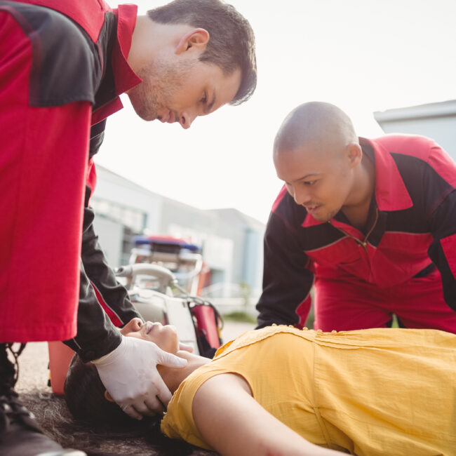 Paramedics examining injured woman on street